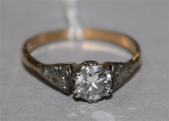 An 18ct gold and platinum single stone diamond ring with diamond set shoulders, size O.